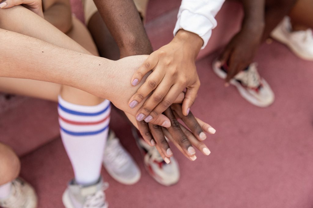 Four people stacking their hands.